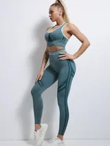Conjunto deportivo de calza larga y top con breteles cruzados en la espalda, color verde azulado con detalles en verde oscuro.