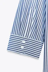 Camisa de mujer con cuello solapa y manga tres cuartos con estampado a rayas verticales verdes y blancas. Cierre frontal con botones ocultos.