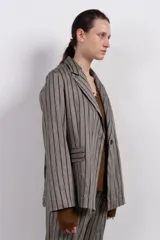 Blazer gris con rayas verticales marrones, solapas de muesca, cierre con un botón y bolsillos con solapa.