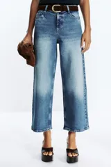 Pantalón de jean azul de corte culotte, tiro alto, pernera ancha y corta. Incluye cinturón marrón de gamuza con hebilla metálica.