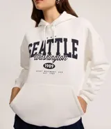 Saco cerrado tipo hoodie blanco con capucha, cordón ajustable, bolsillo canguro y estampa frontal con el texto "SEATTLE Washington 1989".