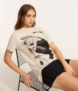 Remera de algodón color crema con estampa frontal de Ariana Grande y texto en negro.