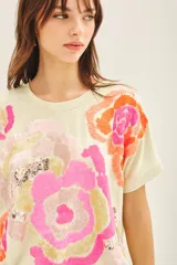 Buzo color crema de rústico de algodón, de calce holgado y manga corta. Posee un bordado central de inspiración botánica con lentejuelas.