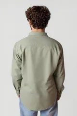 Camisa blanca de manga larga con cuello clásico y cierre frontal con botones.