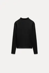 Camiseta blanca de manga larga con cuello alto y corte ajustado.