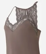 Conjunto de pijama short doll color crema, compuesto por un top de breteles finos con escote en V y detalles de encaje, y un short con cintura elástica y detalles de encaje en los laterales.