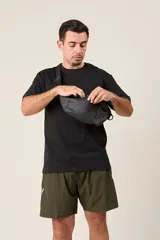 Riñonera negra de tela impermeable con correa ajustable con hebilla.