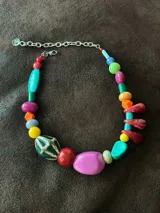Collar corto con cuentas de cerámica, resina y piedras de colores. Cierre con cadena de acero quirúrgico y gancho para regular el largo.