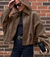 Chaqueta tipo bomber de gamuza color marrón, con cuello camisero, calce suelto y mangas amplias.