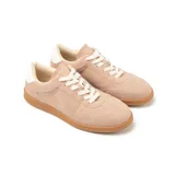 Zapatillas urbanas color nude, de cuero sintético, con cordones blancos y suela marrón.