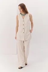 Chaleco color beige confeccionado en lino y rayon, con escote en V y cierre frontal con botones. Diseño clásico y favorecedor.