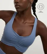 Top deportivo celeste con escote nadador en la espalda y fruncido delantero.
