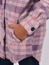 Sobrecamisa larga a cuadros color lila, rosa y borgoña, con cuello camisero y cierre frontal con botones negros.