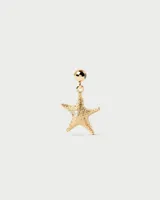 Dije de oro con forma de estrella de mar y un pequeño brillante incrustado.