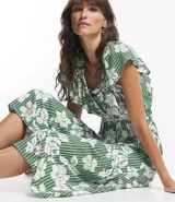 Vestido midi de viscolino con estampado de flores blancas y rayas verticales verdes. Tiene escote en V, mangas cortas amplias y cintura elástica.