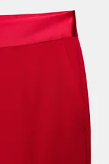 Pantalón negro de tiro alto con corte flare y cinturilla combinada. Presenta bolsillos laterales y falsos bolsillos de vivo en la espalda. Cierre frontal con cremallera, botón interior y gancho metálico.