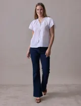 Blusa blanca de algodón marca Cupio, con cuello a la base, escote en V y lazo de ajuste. Presenta bordado en la parte delantera y mangas cortas amplias con aplique de puntilla.
