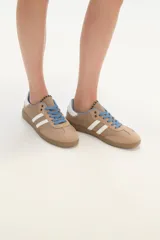 Zapatillas deportivas color rosa con detalles en marrón, cordones marrones y suela color caramelo.