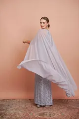 Vestido largo de encaje color plata con brillos y cuello halter. Incluye capa de gasa larga.