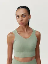 Top cropped verde de sujeción media, sin costuras, con tejido Fit_Tech con tecnología 3D, juego de texturas y hombros anchos. Diseño elegante y favorecedor con copas extraíbles.