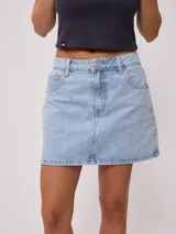 Minifalda de jean azul con bolsillos delanteros y traseros, tiro alto y corte recto.