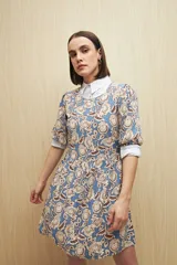 Vestido corto con estampado animal print en tonos beige, negro y marrón. Tiene corte holgado, mangas cortas y falda con vuelo.