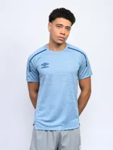 Remera de entrenamiento celeste con detalles en azul en cuello y hombros. Logo de Umbro estampado en el pecho.