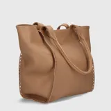 Bolso tipo tote de cuero color beige con textura granulada y tachas plateadas en los laterales.
