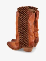 Bota de cuero color marrón con caña media y detalle de tramado en los laterales. Diseño de punta fina y taco ancho bajo.