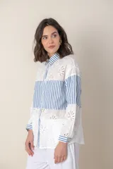 Camisa blanca de algodón con bordado calado y rayas celestes.