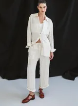 Sandalia roja de cuero vacuno con diseño de tiras entrecruzadas y hebilla lateral. Tiene suela de cuero artesanal y taco bajo.