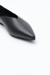 Zapato bajo de punta fina, color marrón oscuro, de acabado liso y estructura flexible.