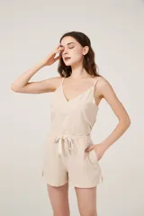 Conjunto de pijama de satén a rayas verticales color beige, compuesto por un top con breteles finos y escote en V, y un short de calce holgado.