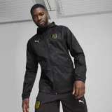 Campera deportiva Puma de hombre, color negro, modelo CAP Train All Weather. Presenta cierre frontal completo, capucha y logo de Puma estampado en plateado en el pecho. Incluye escudo del Club Atlético Peñarol bordado en dorado.