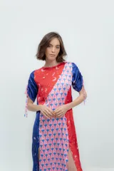 Vestido midi con estampado de cerezas, corte asimétrico, mangas cortas abullonadas con lazos y tajos laterales. Diseño en seda combinada con paneles en color rojo y azul.