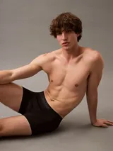 Pack de tres bóxers ajustados Calvin Klein, uno negro, uno gris y uno azul marino, con cintura elástica con logo de la marca.