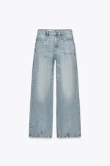 Pantalón de jean celeste de tiro alto y corte wide leg. Tiene bolsillos delanteros y traseros, costuras verticales en el frente, y cierre frontal con cremallera y botón metálico.
