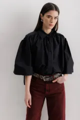 Camisa celeste de algodón con corte amplio, cuello camisero y mangas largas con puños abullonados.