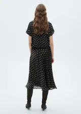 Falda midi negra con estampado de lunares color dorado.