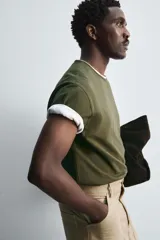 Camiseta verde militar de corte holgado confeccionada en tejido de algodón compacto. Cuello redondo con ribete doble y mangas cortas.