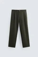 Pantalón verde oscuro de corte amplio confeccionado en tejido de lyocell. Presenta pliegues frontales, bolsillos laterales y traseros de ojal. Cierre frontal con cremallera y botón.