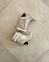 Botines dorados de cuero vacuno con punta fina y tacón aguja.