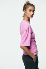 Camiseta rosa entallada de algodón con cuello redondo y mangas cortas.