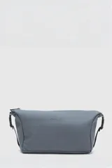 Neceser gris con el logo de la marca en negro. Cuenta con un compartimento principal con cierre, un bolsillo lateral para accesorios y un bolsillo interior con cierre. Tiene una capacidad de 5.77 litros.