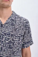 Camisa casual de viscosa con estampado geométrico en tonos blanco y negro, de manga corta y cuello americano.