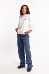 Remera blanca de corte cuadrado con cuello subido y mangas 3/4 amplias.