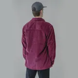 Camisa celeste de pana con corte oversize, cuello clásico, cierre frontal con botones, dos bolsillos con solapa en el pecho y mangas largas con puños abotonados.