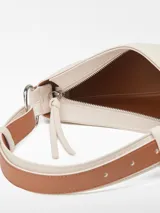 Bolso de hombro tipo baguette color crema, con textura granulada y asa corta regulable.