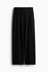 Pantalón sastrero negro de corte holgado con tiro alto y cierre con corchete y botón ocultos. Piernas amplias con pinzas, pliegues adelante y atrás, bolsillos al bies y bolsillos decorativos atrás.