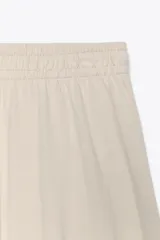 Pantalón de algodón color beige, de tiro medio, pierna ancha y cintura elastizada.